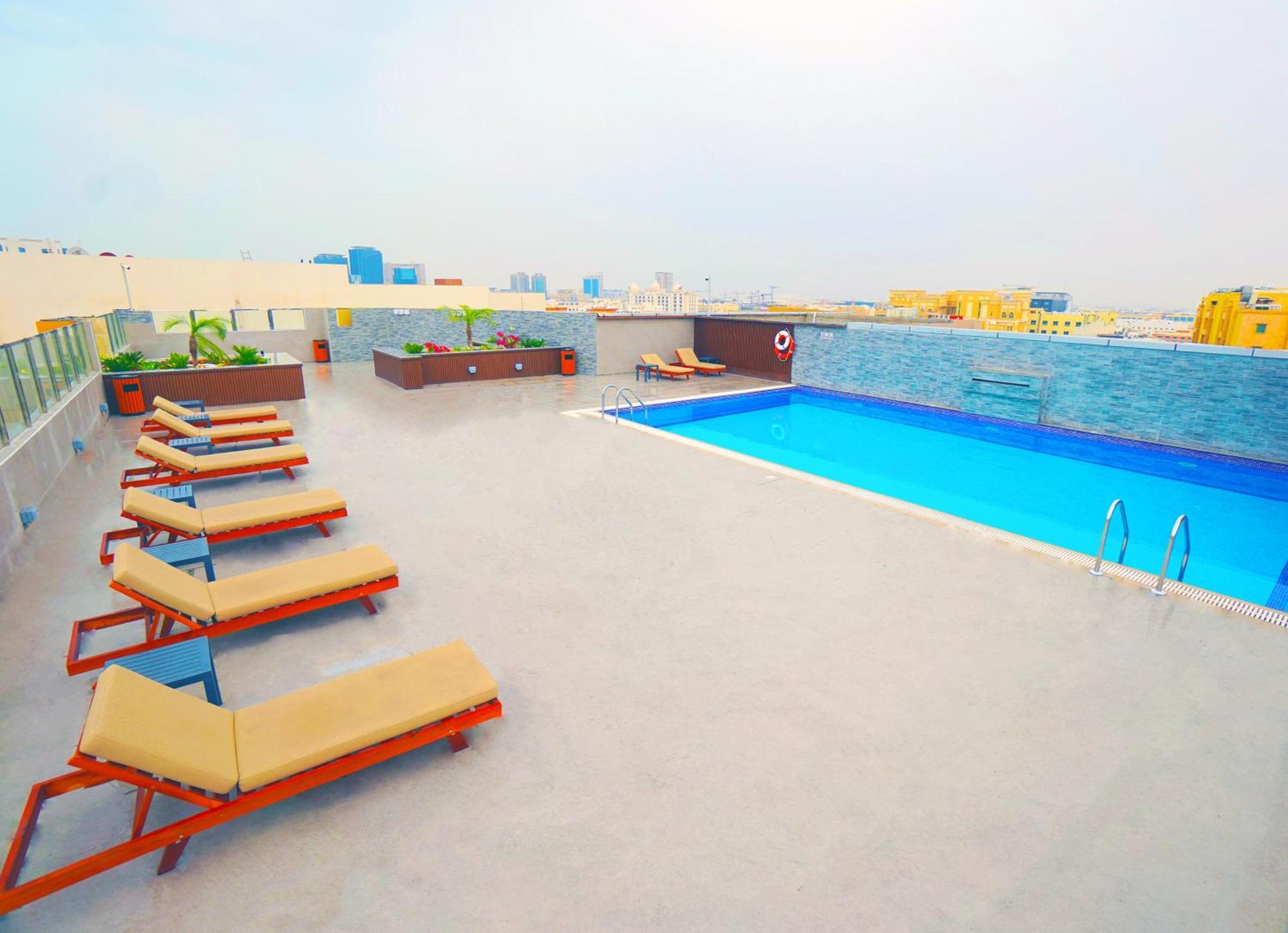 The Grand Lux Hotel Dauhá Exteriér fotografie Rooftop pool at the hotel